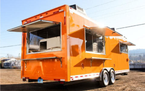 An orange food truck with polished chrome accents