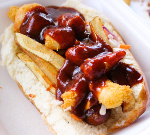 A close up of an Andouille Sausage topped with shrimp